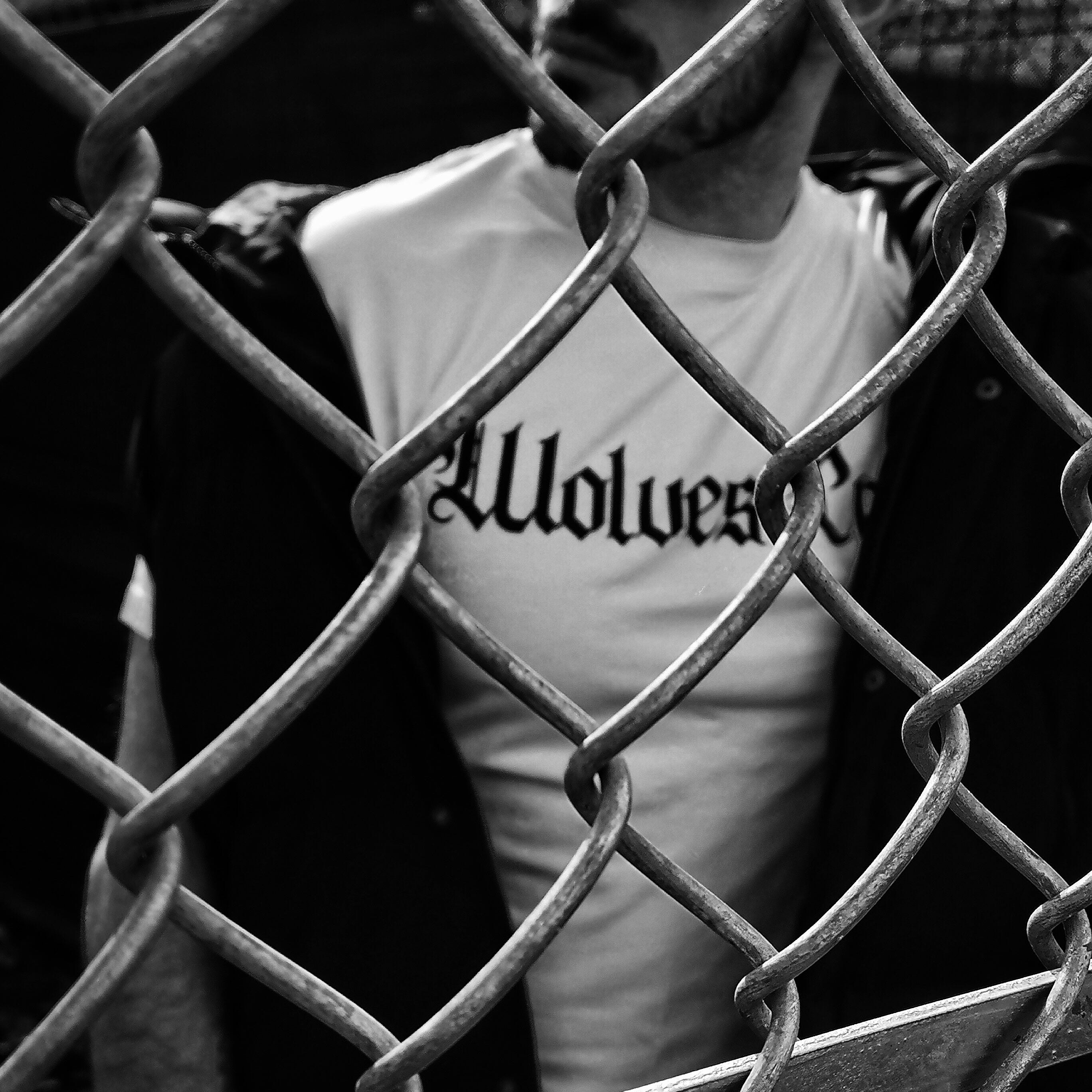 Close-up detail of the Wolves Cry Spell-Out Tee in white, highlighting the bold black logo on the soft, premium cotton fabric.