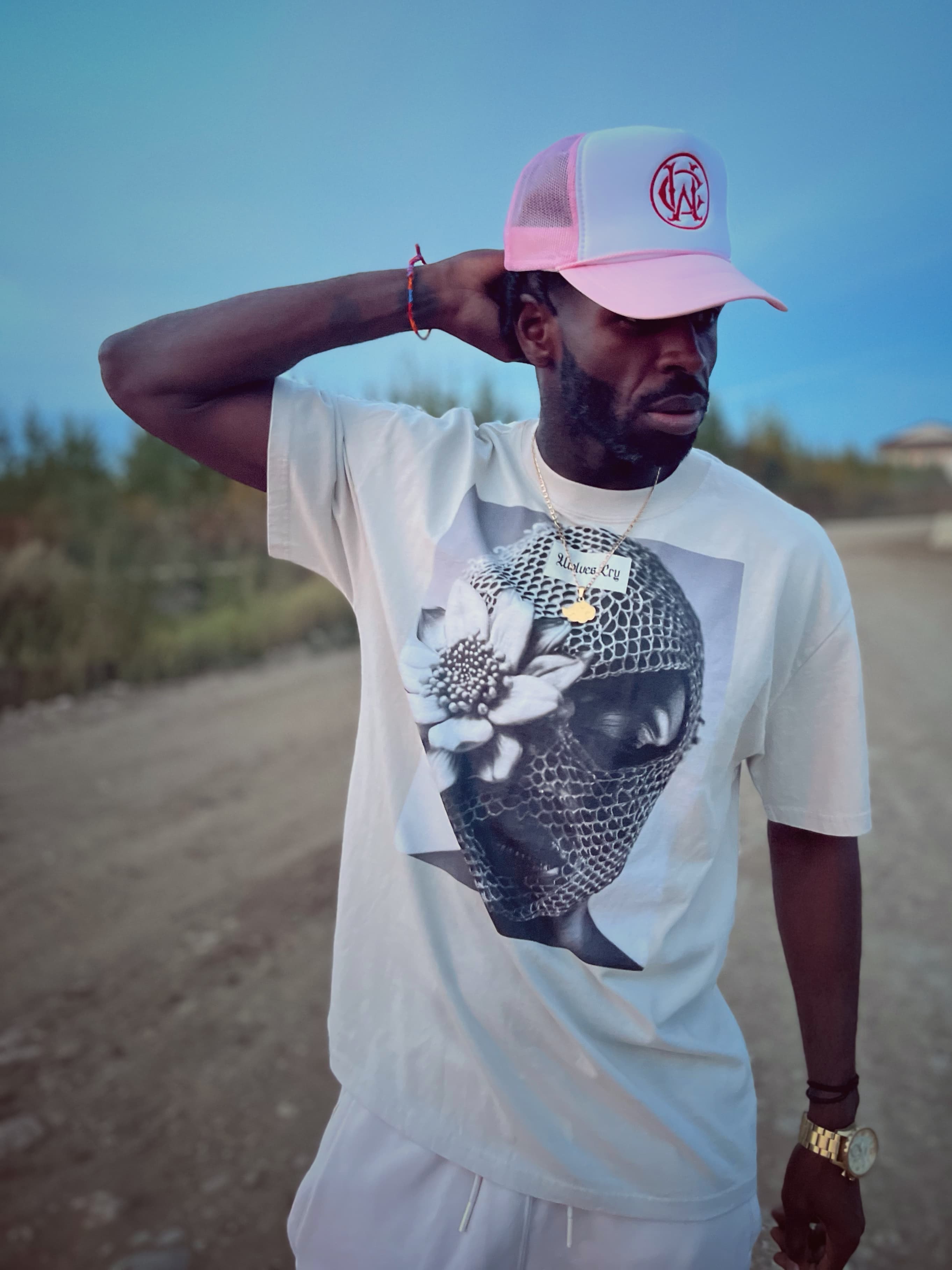 Model posing outdoors in the oversized balaclava tee in bone white, with a casual fit and bold streetwear aesthetic.