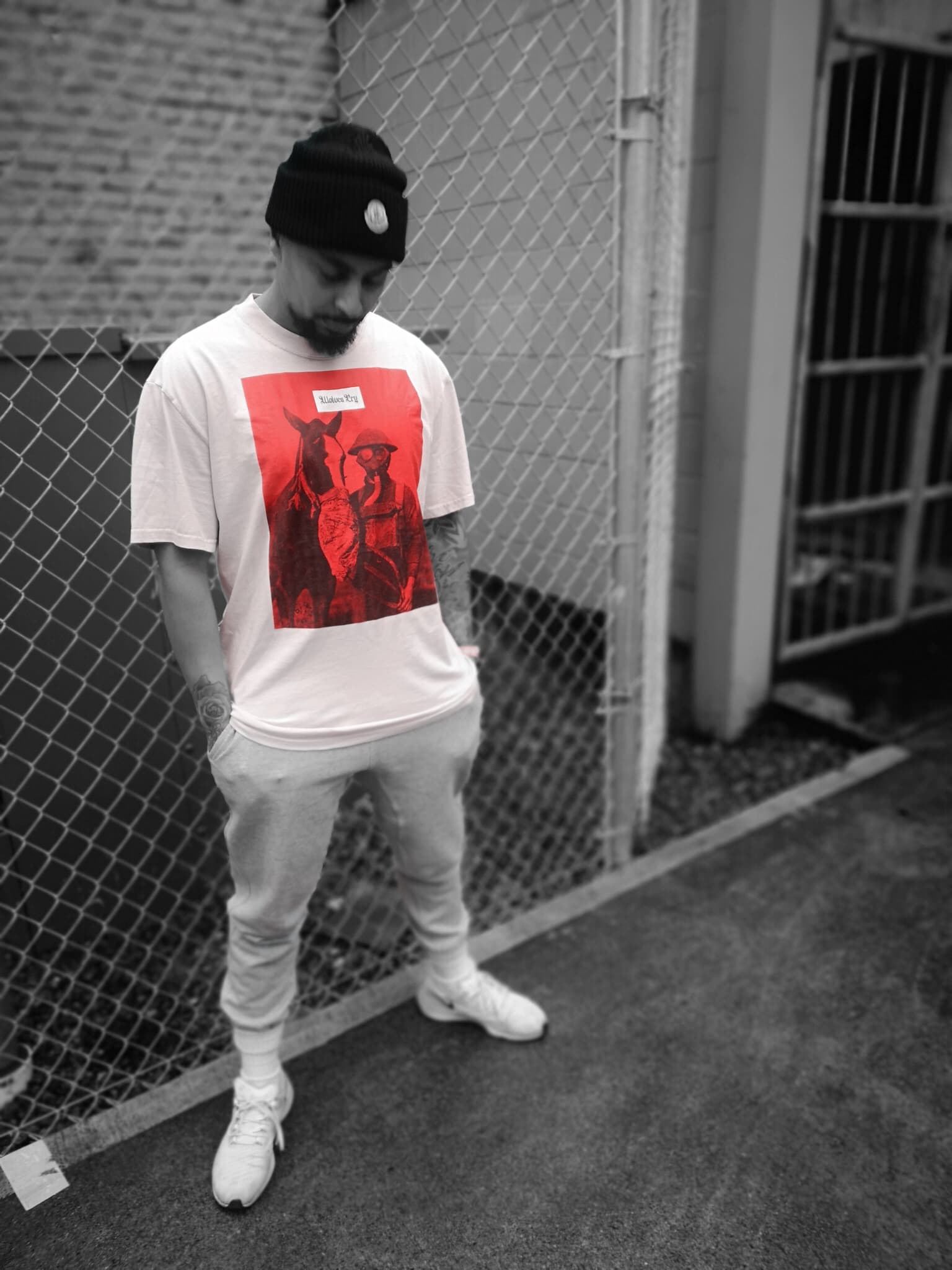 Wolves Cry Equestrian Red Remix Tee displayed in an urban setting. Oversized fit, garment-dyed cotton, and bold streetwear aesthetic captured in detail.